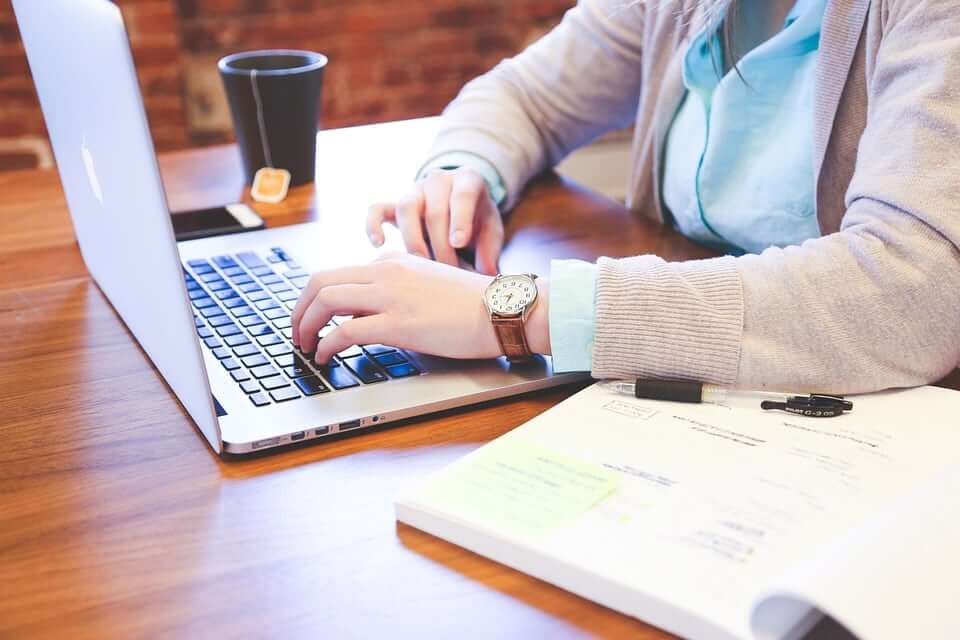 A woman typing on her laptop.