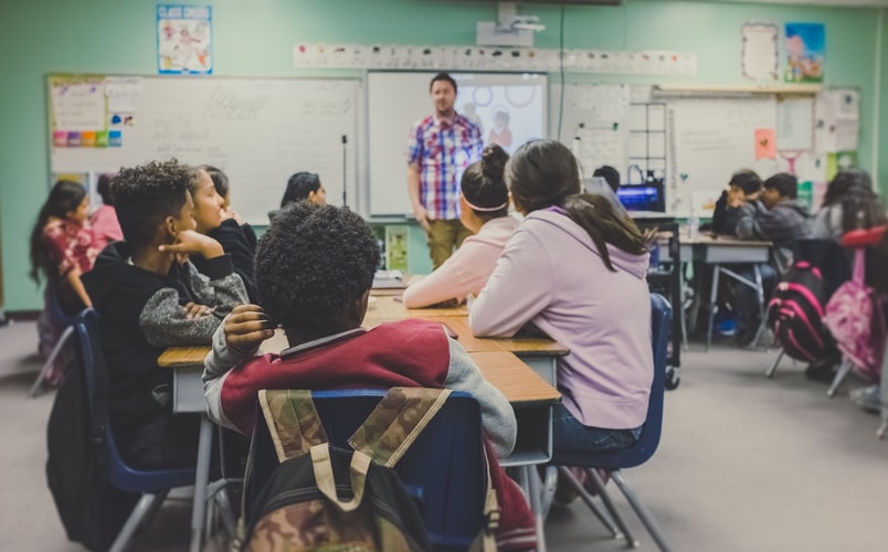 Children listening to the teacher in front of them.