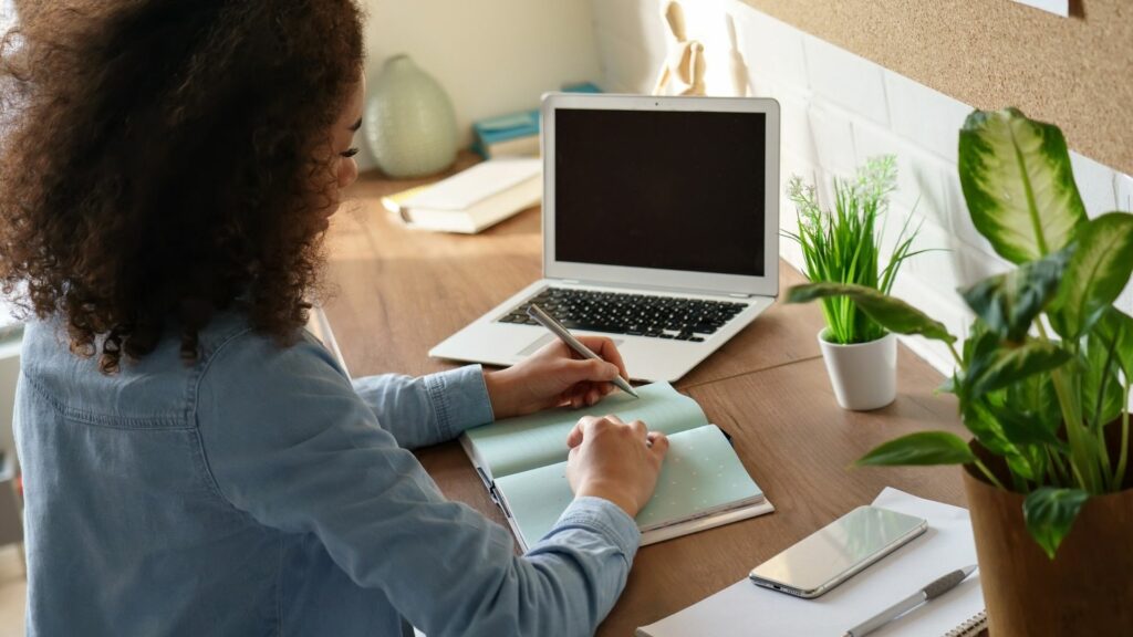 A woman writing on her notebook.