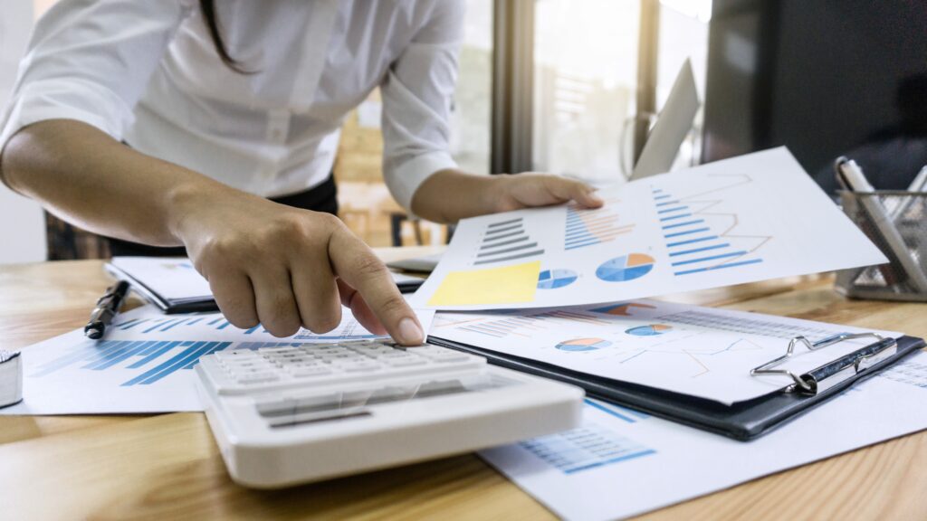 accountant with calculator and statistics on desk