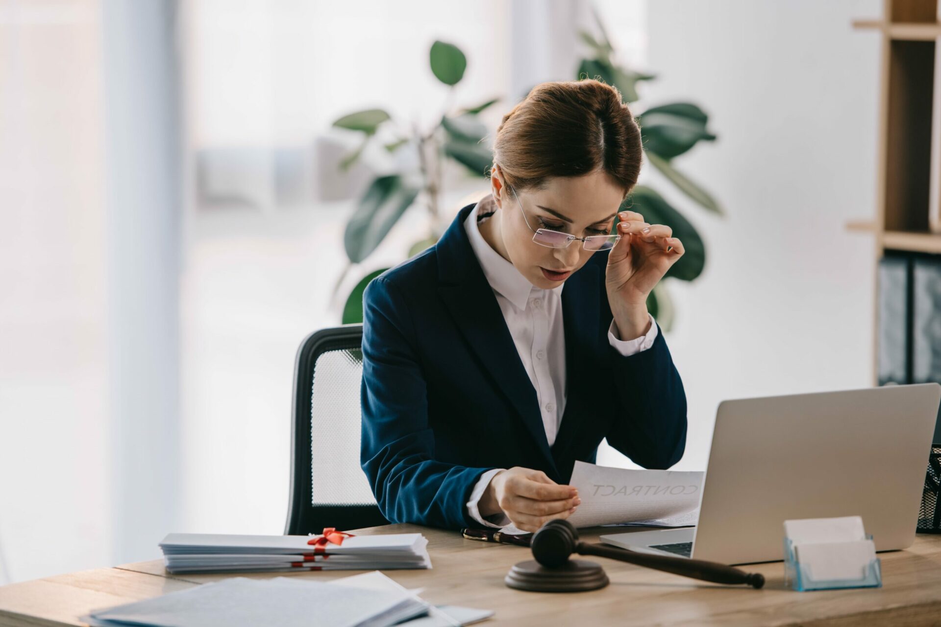 Female lawyer with laptop and grave on desk