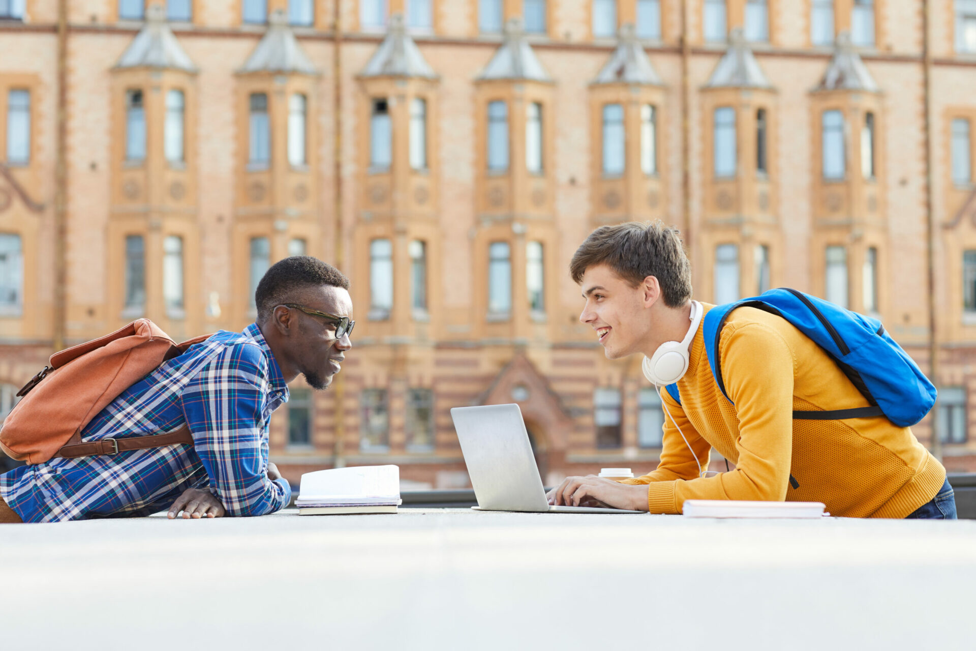 male students with laptop outside university