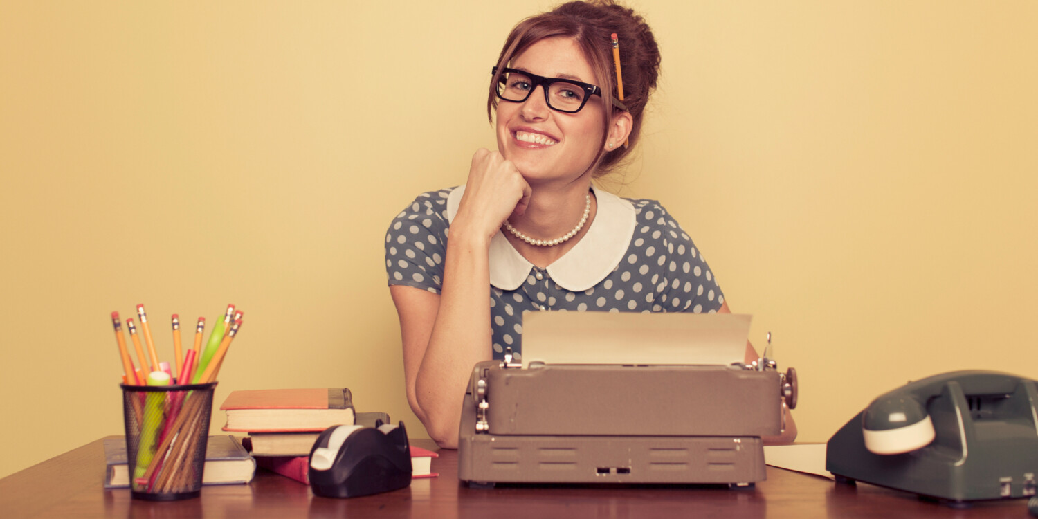 A woman with pencils, a typewriter, and a telephone on her table