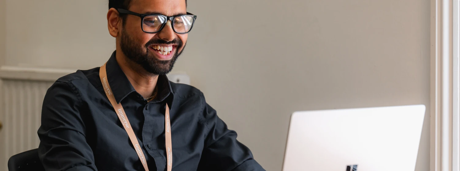 a man smiling to the laptop