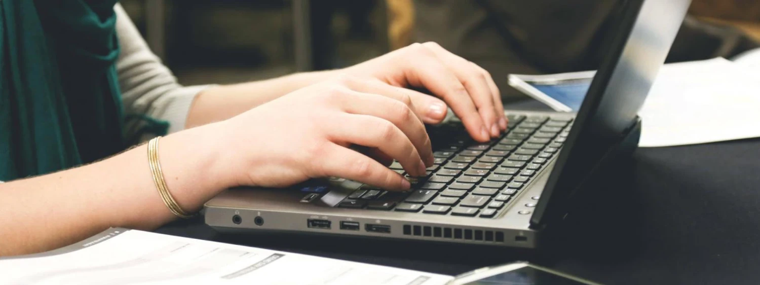 A person typing on his laptop