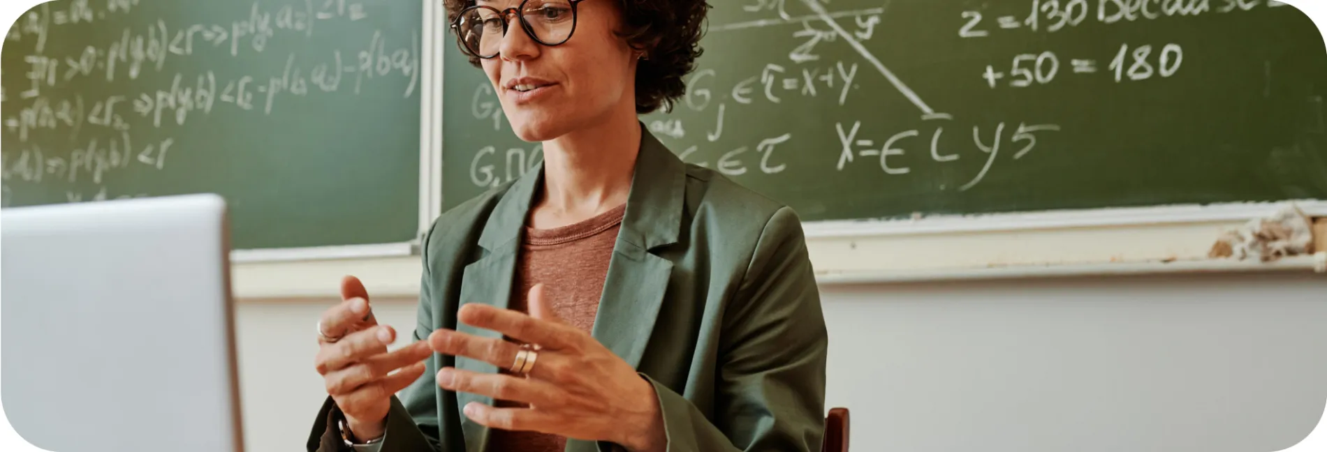 A woman wearing an eyeglasses explaining with a laptop