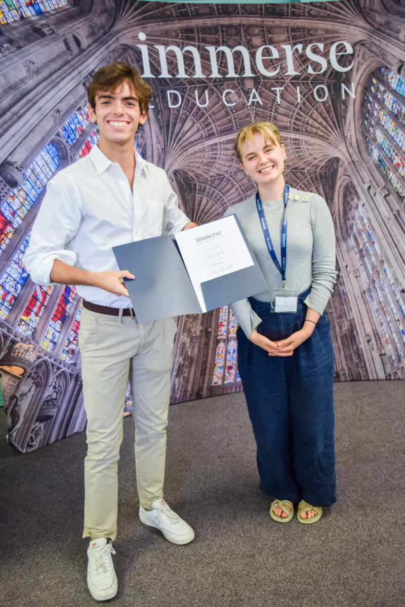 A man showing a diploma with a woman beside him.