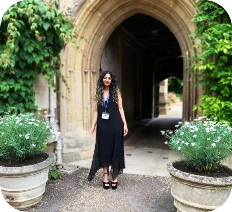 a woman standing in front of a stone archway