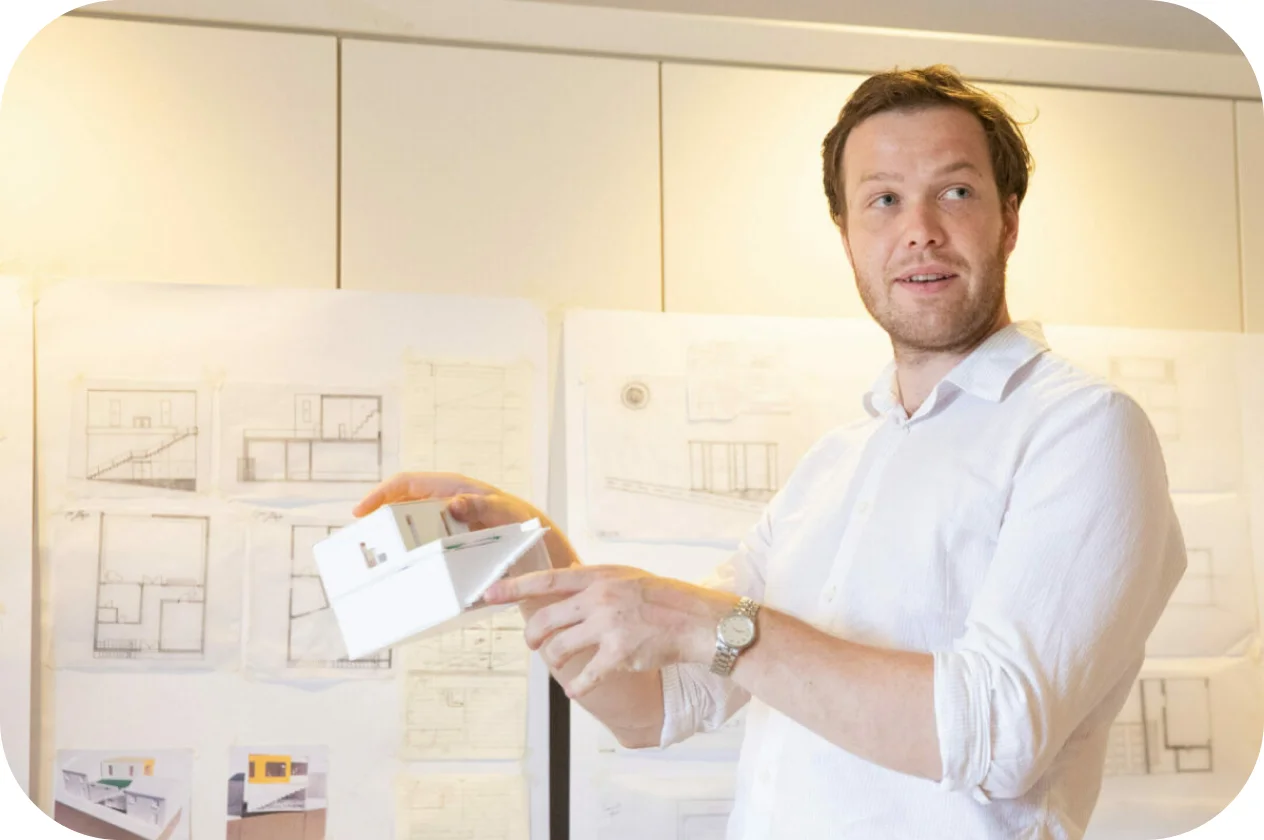 A man holding a model of a house