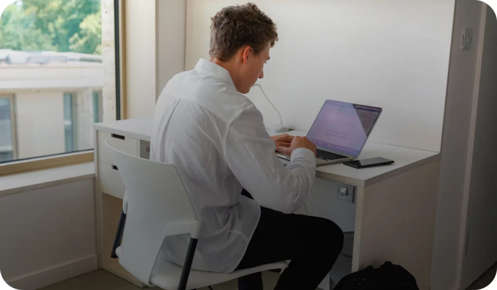 a man sitting at a desk using a laptop