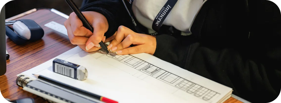 A student draws using a ruler