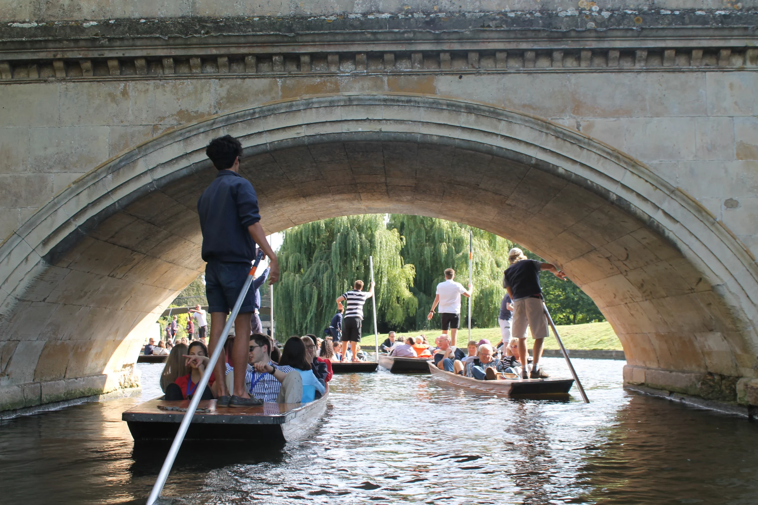 a group of people on a boat under a bridge