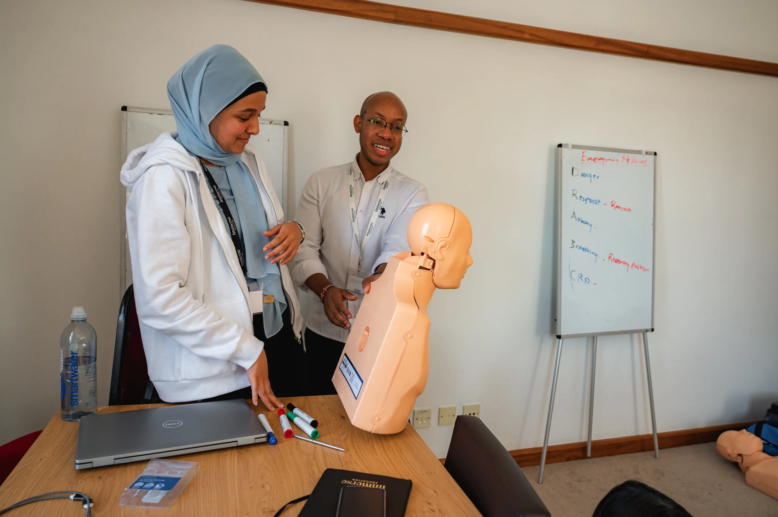 Two people explaining while using a half-body mannequin