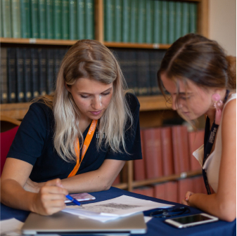 Two women collaborating with a book