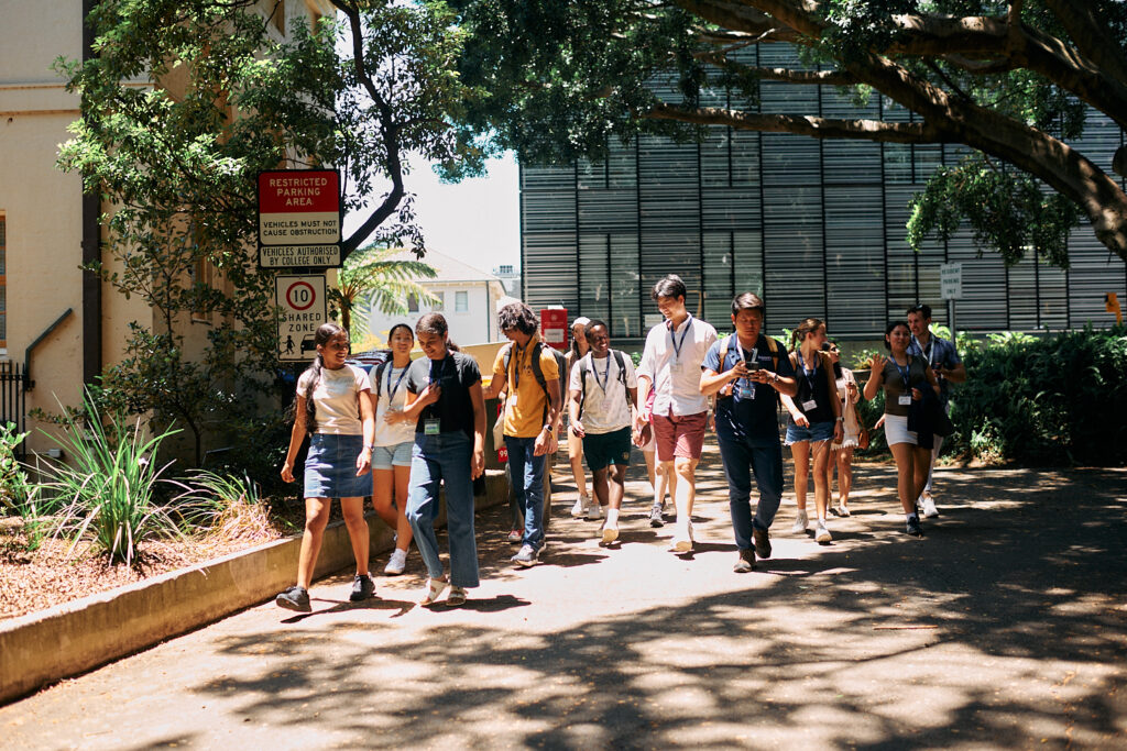a group of teenagers walking on a sidewalk during their school holidays