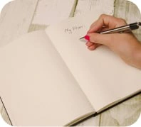 a hand holding a pen, writing in a notebook