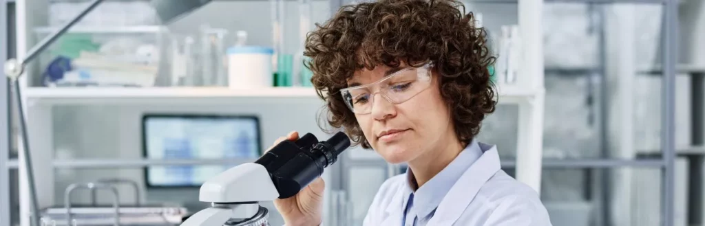 Scientist looking through microscope