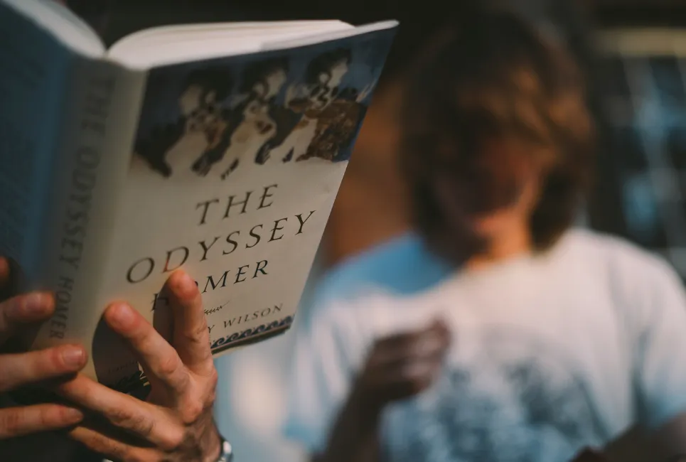 Hand holding a literature book, while friend watches