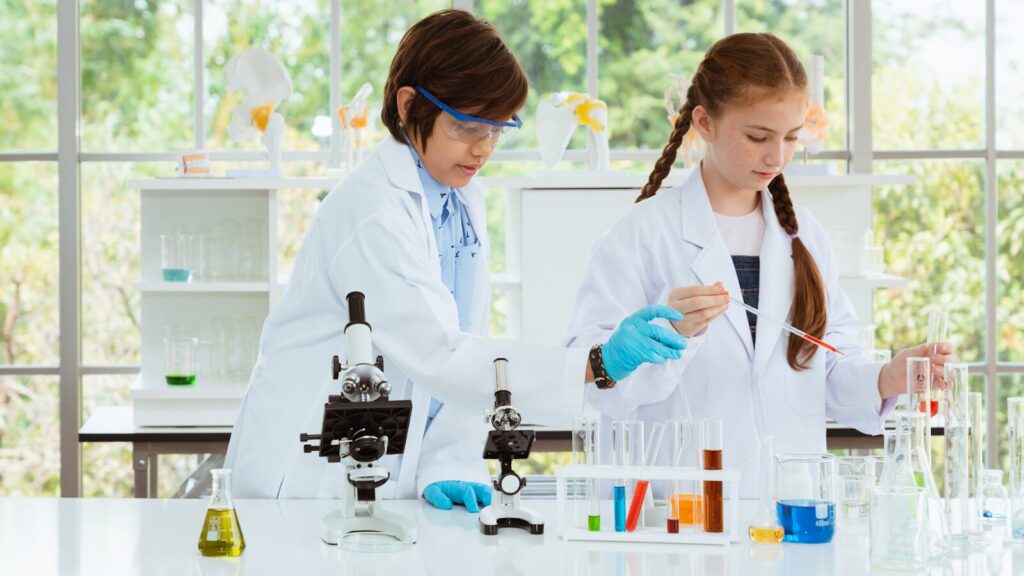 Two teens in a lab with leaves out the window, working and studying on how to get into the University of Adelaide