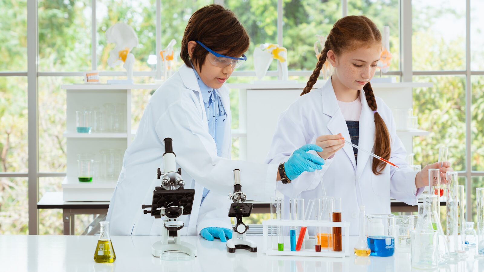 Two teens in a lab with leaves out the window, working and studying on how to get into the University of Adelaide