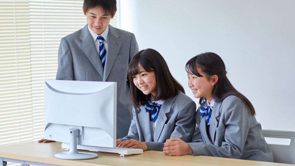 Three teenagers searching online on how to get into the University of Queensland