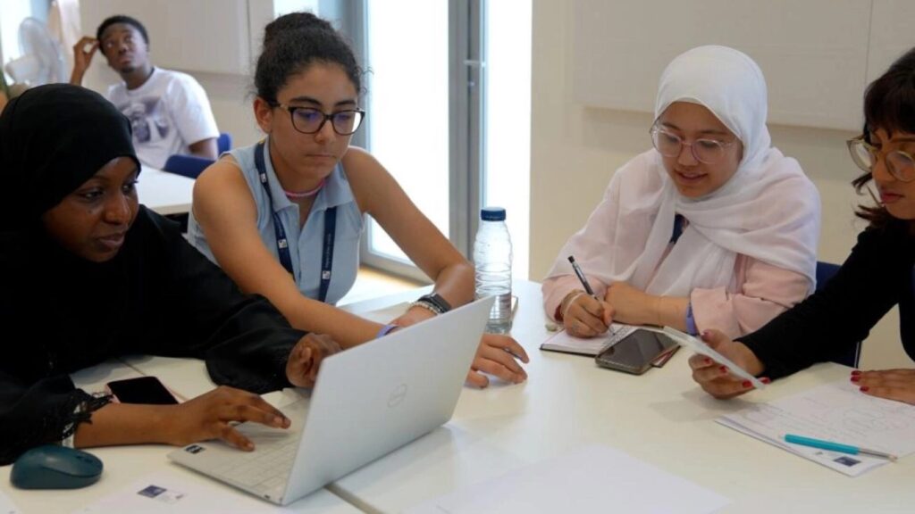 A group of students sitting together on a table and studying