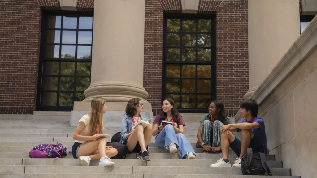 A group of students sitting on university steps and discussing something