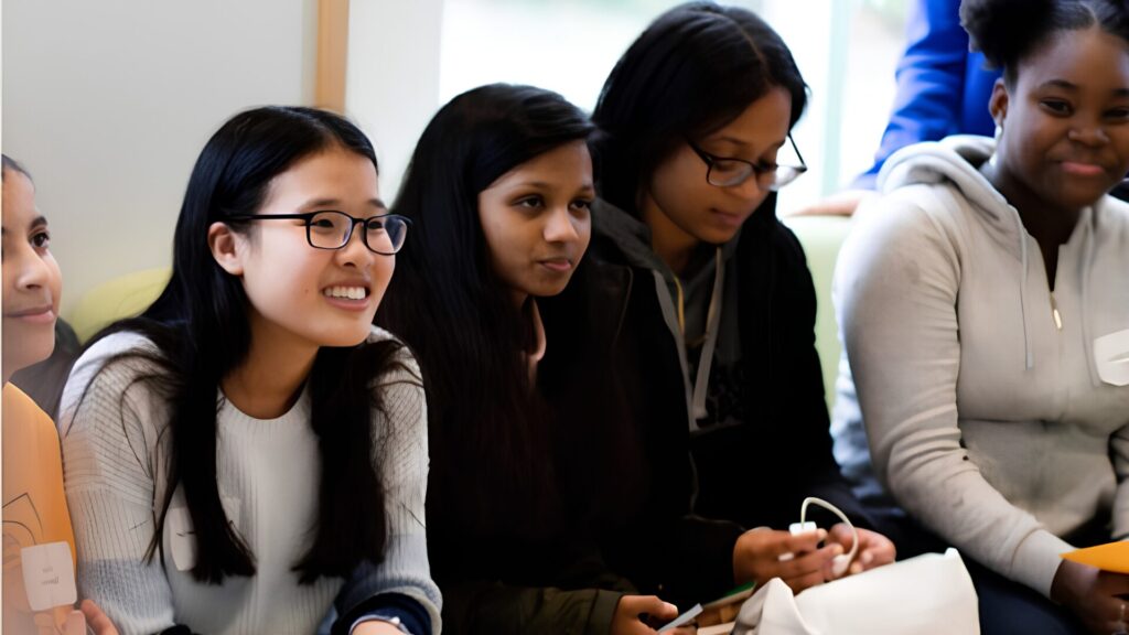 A group of students sitting next to each other and holding pamphlets