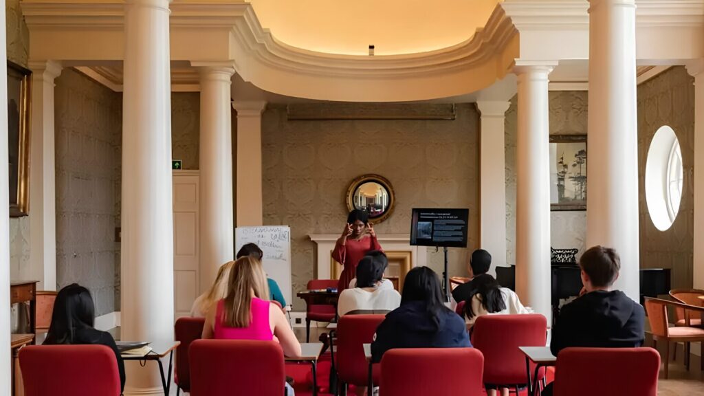 A group of students attending a law in a classroom with pillars